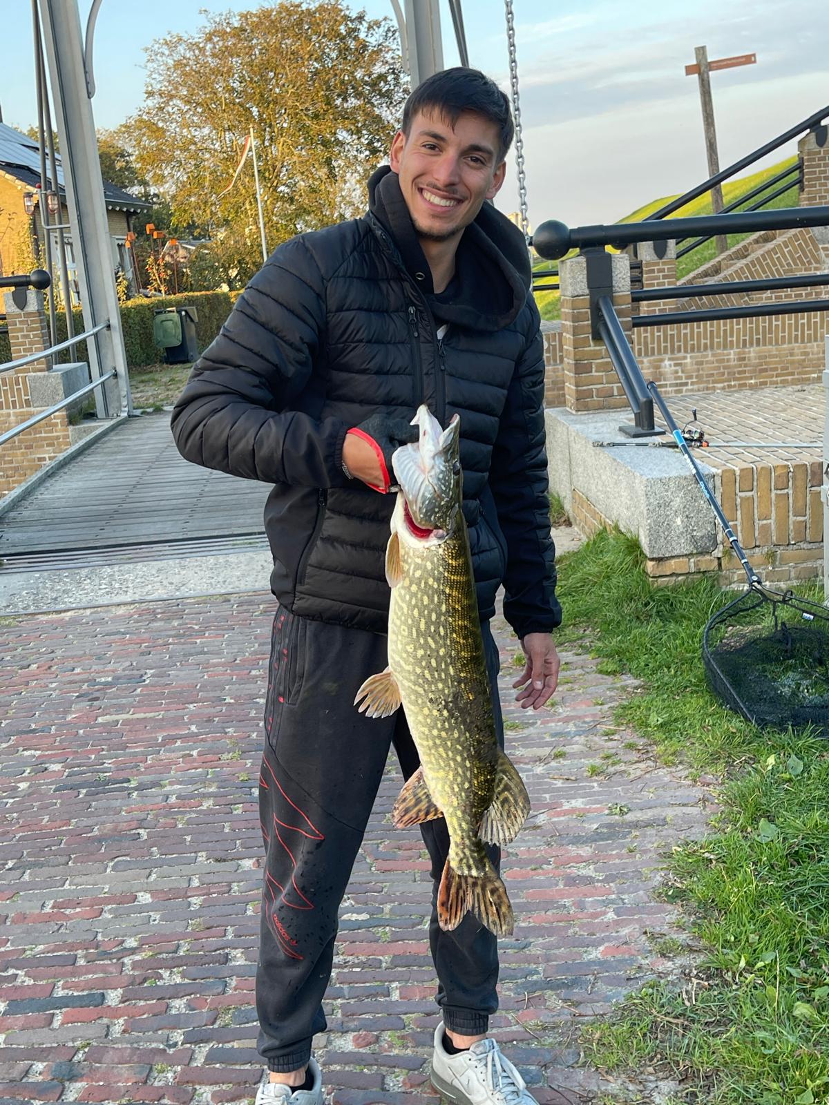 Angler mit großem Hecht im Herbst